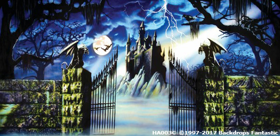 A haunted castle looms in the distance behind a wrought iron gate flanked by gargoyle statues. The scene includes a full moon, bats, lightning in the sky, and fog covering the ground—perfect as a party backdrop.