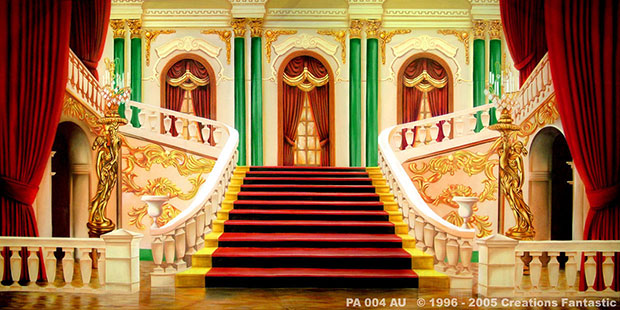 Ornate grand staircase in a lavishly decorated palace interior with red carpets and green columns, bordered by red curtains. The architectural design includes intricate gold detailing on the white walls.