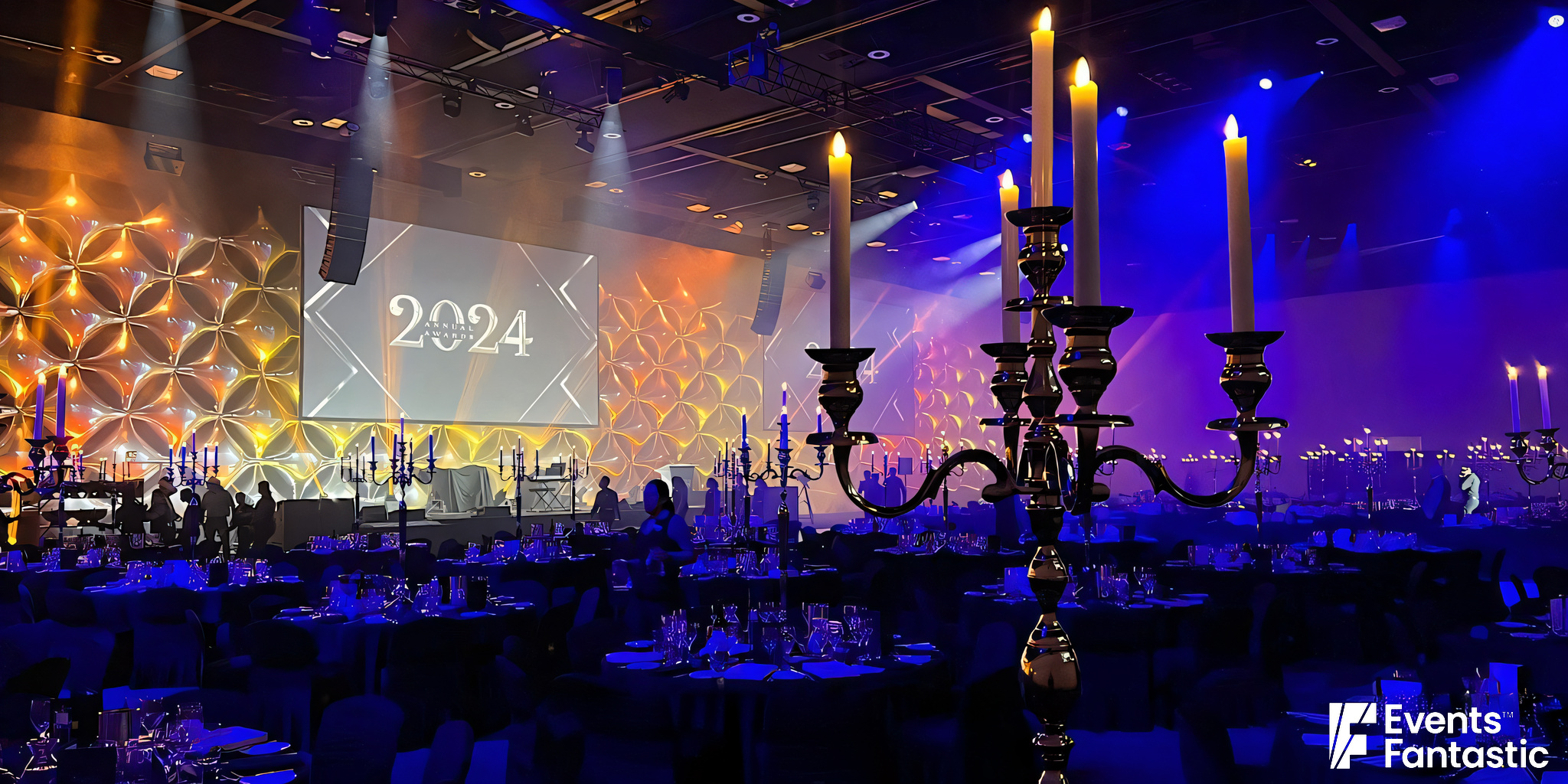         A lavishly decorated event hall features 1.2m chrome 5-prong candelabra and a large screen displaying "2024" among mood lighting. Text reads: "©2024 Events Fantastic.