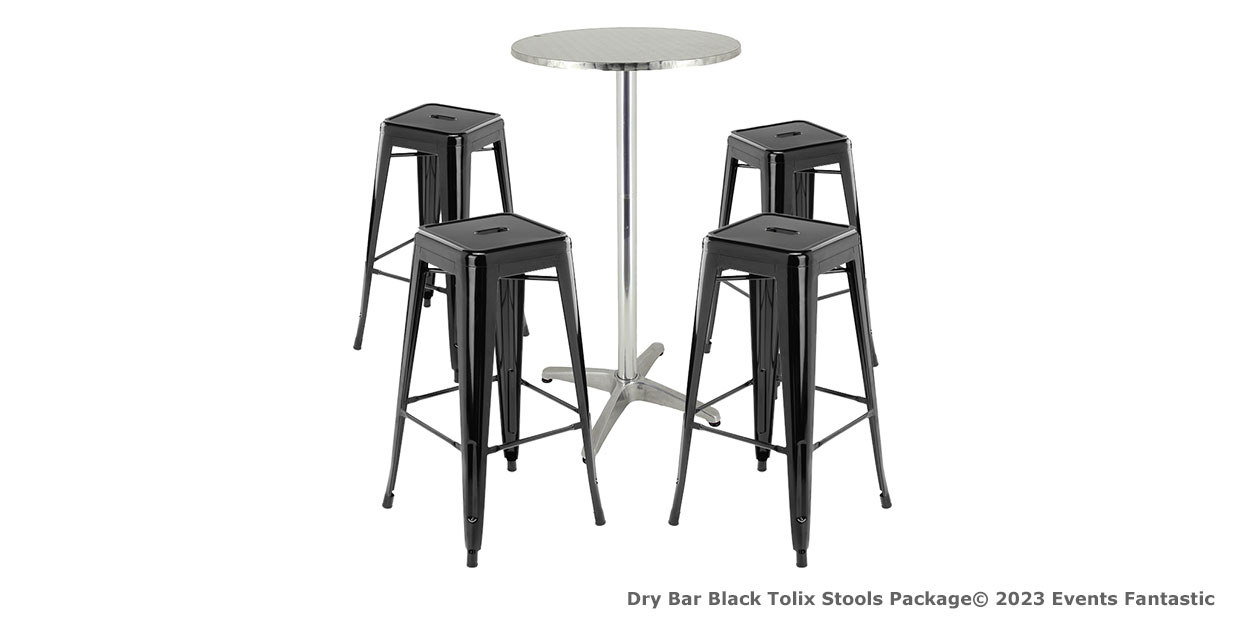 A round silver table with a metal pedestal base is complemented by four sleek black Tolix stools.