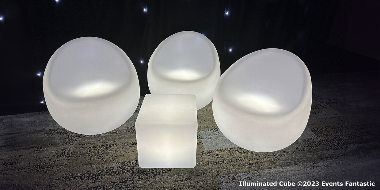 Three modern illuminated chairs and a glowing cube table set against a dark background. The elements emit a soft white light, reminiscent of a large illuminated glow bar. Text in the corner reads: “Illuminated Cube ©2023 Events Fantastic.”