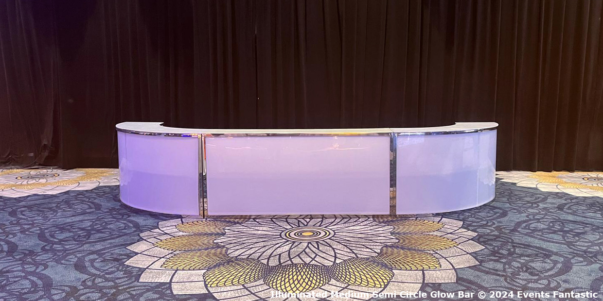 An illuminated semi-circular bar with a glossy white countertop stands against a dark draped background on a patterned carpet, creating the perfect glow bar ambiance.