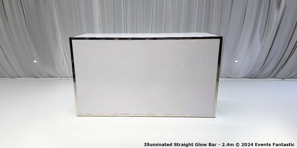 A sleek, metallic-framed Straight Glow Bar, illuminated brilliantly, stands against a draped curtain backdrop on a white floor. Measuring 2.4m wide, this striking piece adds a modern touch to any setting.