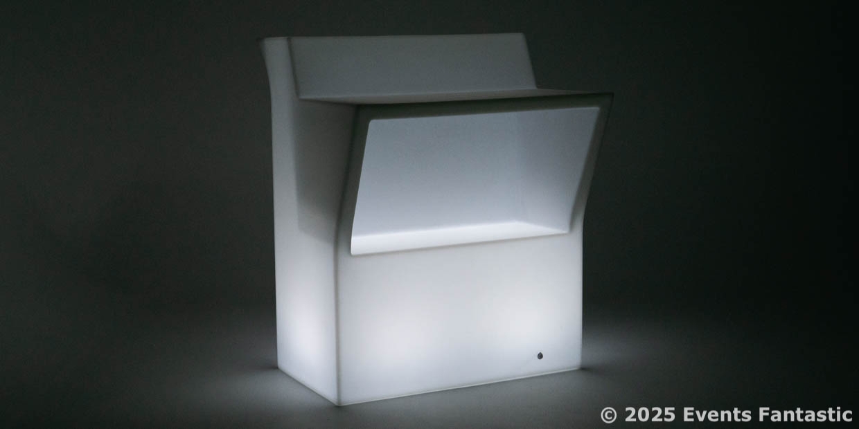 A white Illuminated Bar Counter with a modern design is set against a dark background, creating a striking visual effect. The image is credited to © 2025 Events Fantastic.
