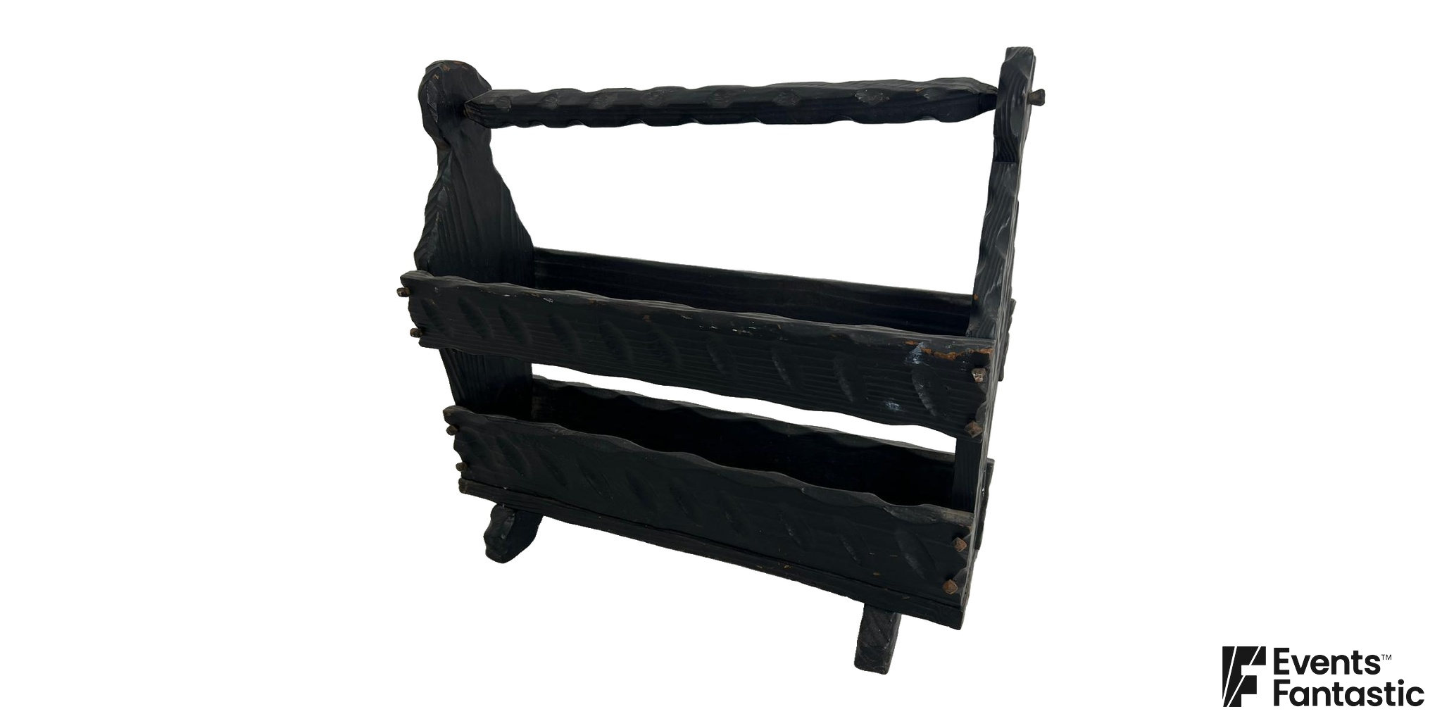 Carved Black Timber Magazine Rack with gouge carved black boards, two open troughs under a top rail and shaped feet, available to hire.