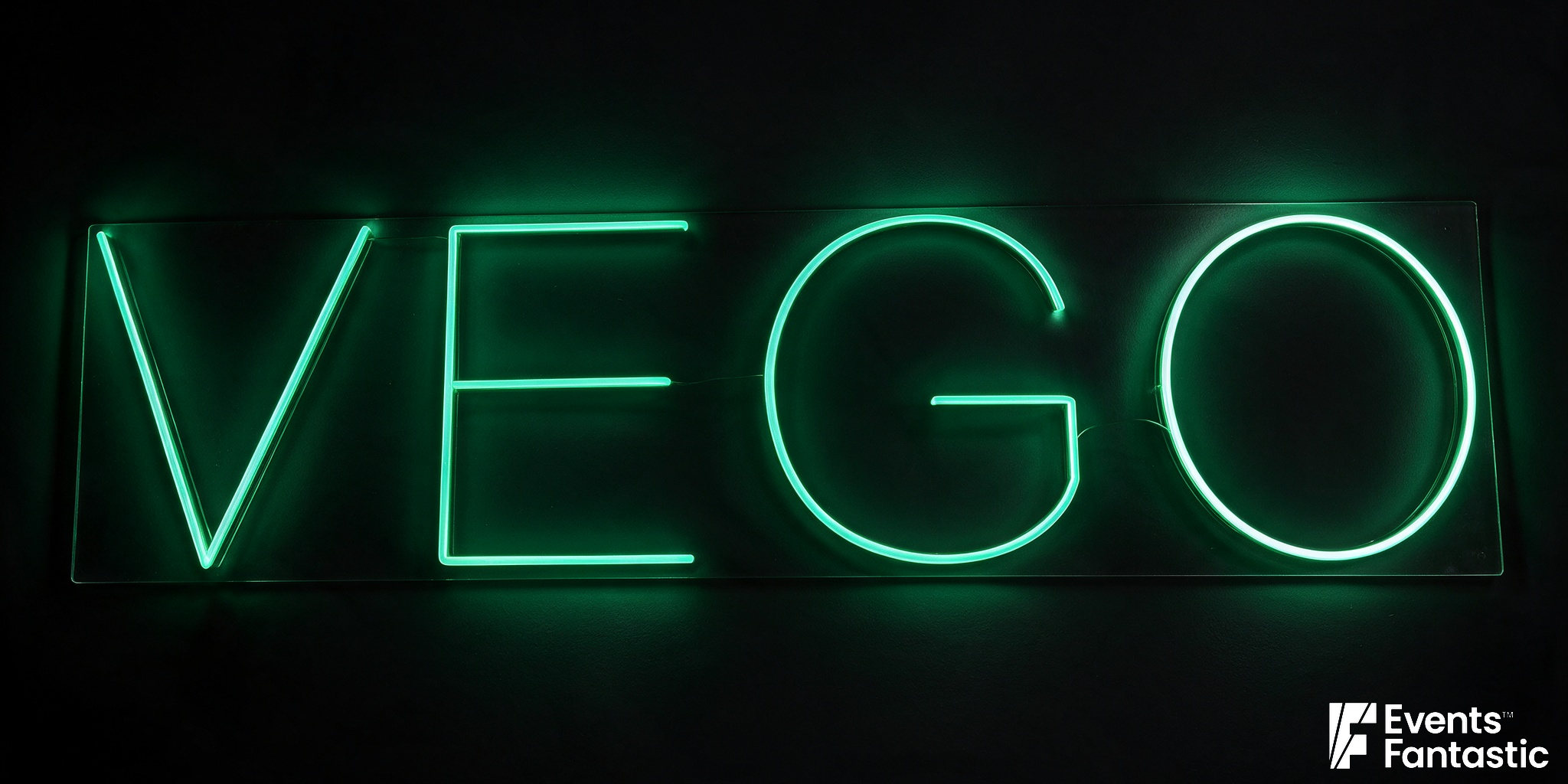 Green illuminated Vego sign in capital letters on a clear rectangular backing panel.