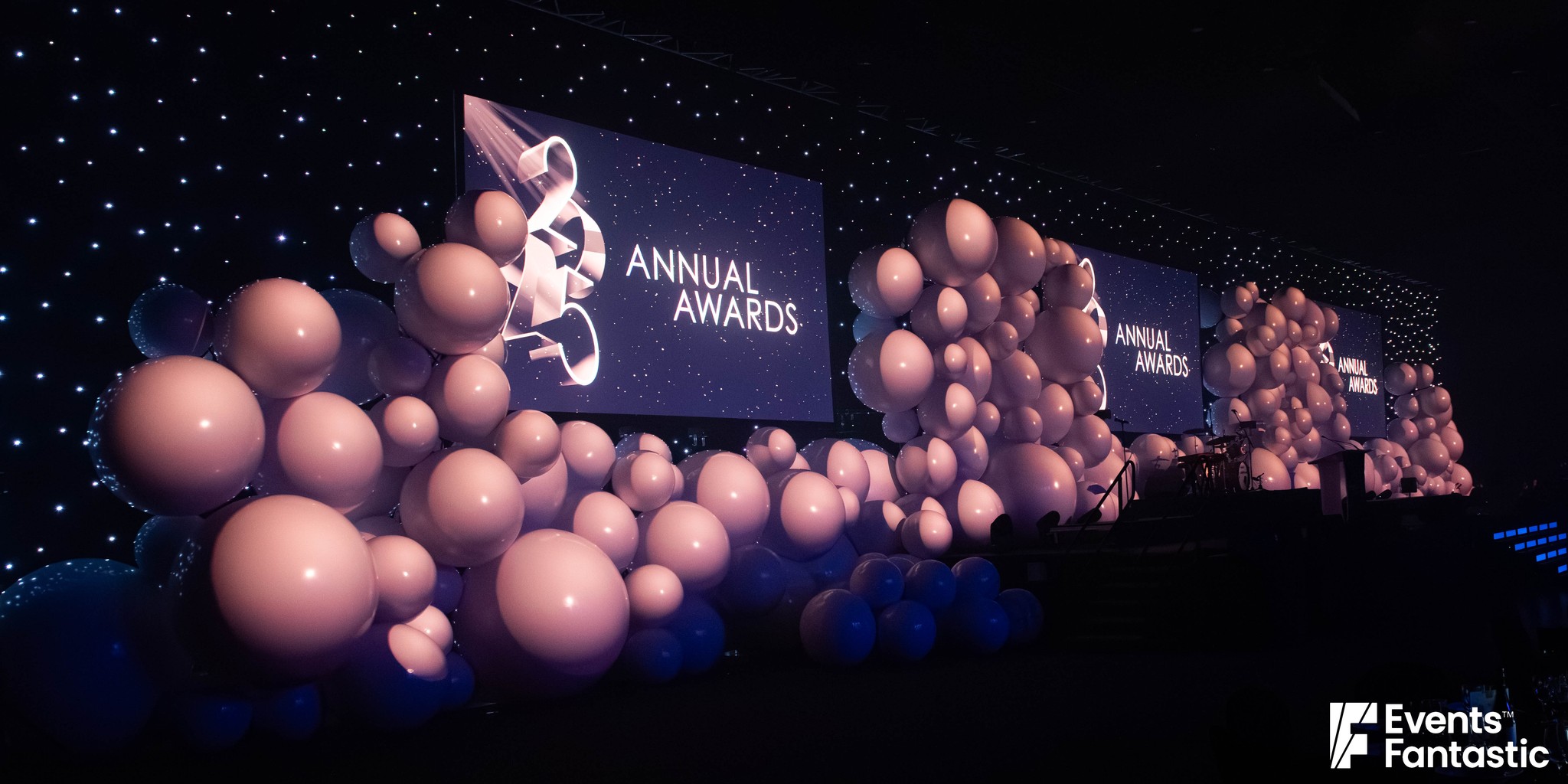 Side view of three walls of inflatable white matt balls between the stage screens, hire from Events Fantastic.
